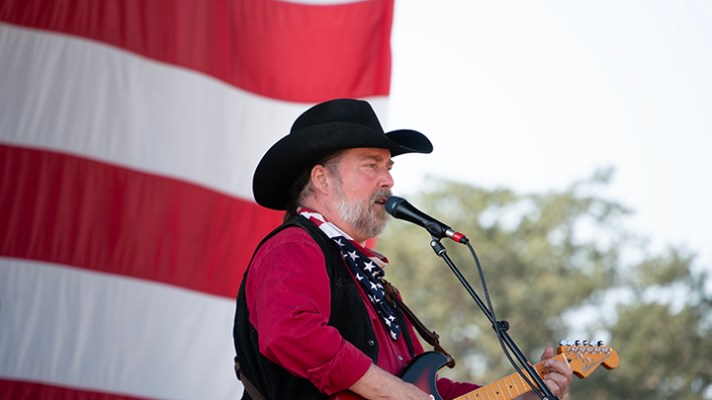 buck ellard singing with american flag in background